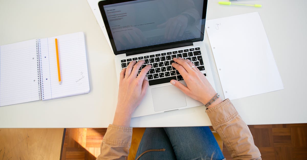 Woman working on laptop with documents